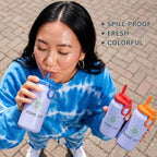 A woman outdoors holds three Home Sip water bottles, one in each hand, with a text overlay listing features: 'SPILL-PROOF', 'FRESH', and 'COLORFUL'. The bottles are lavender with different colored lids (blue, red, orange) and a green flower logo.